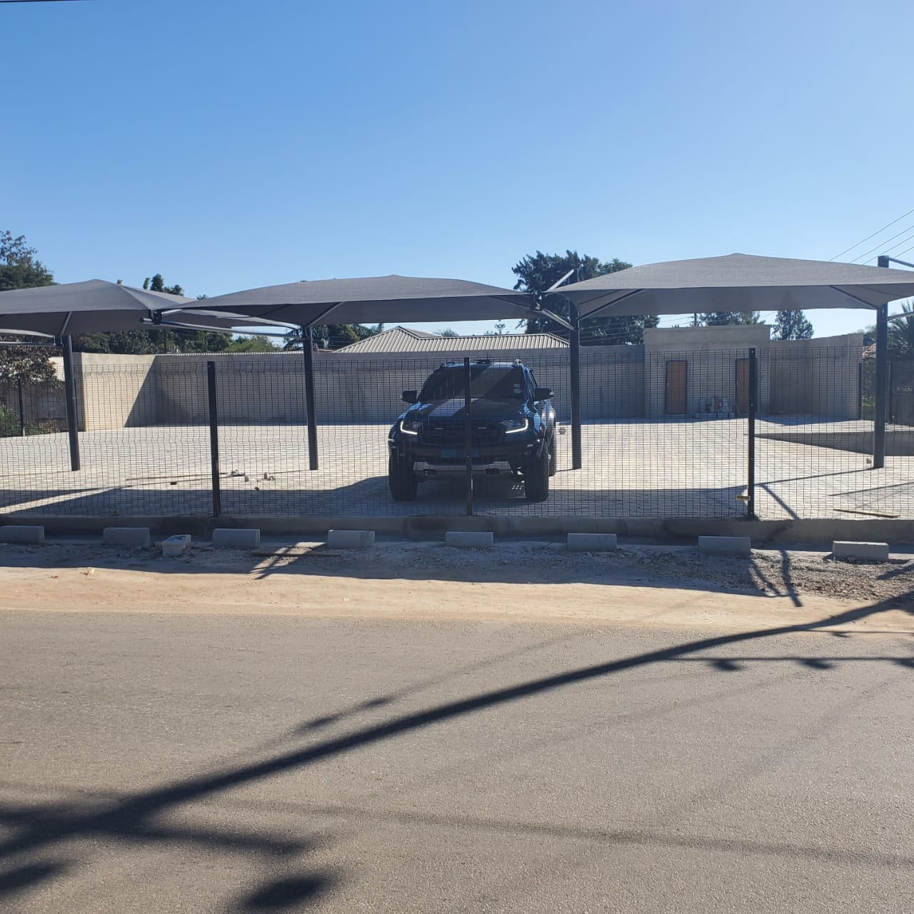 Finished yard with shaded parking bays and perimeter fencing