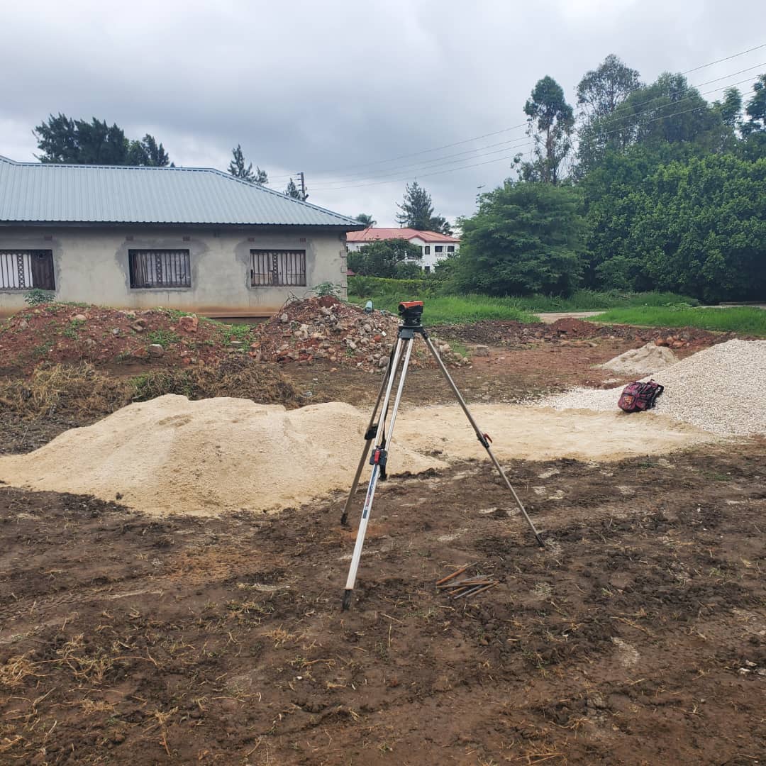 Surveyor's level set up on a cleared plot before excavation begins